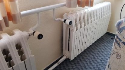 Unter einem Fenster sind zwei große, alte Guss-Radiatoren montiert.