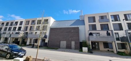 Zwischen neugebauten Reihenhäusern steht eine Nahwärmezentrale.