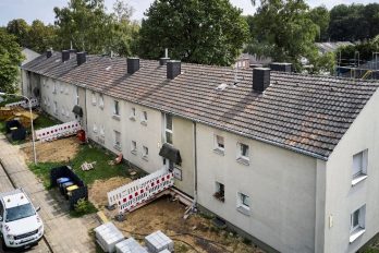230822_0049_ret_k.jpg)(Alt-Text: Eine Baustelle zieht sich rund um einen Wohngebäuderiegel.