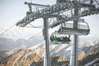 Sessellift transportiert Skifahrer
