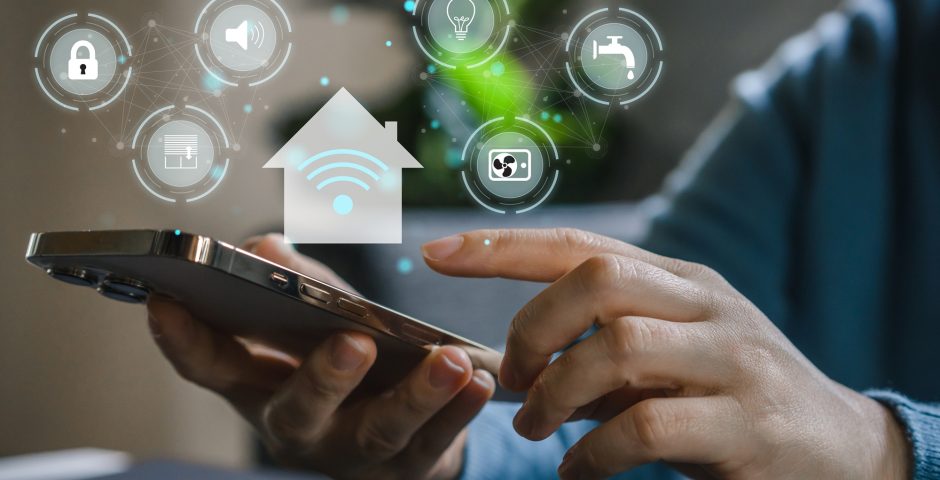 Eine Hand bedient ein Smartphone, in Kreisen ringsherum verschiedene Smart-Home-Symbole