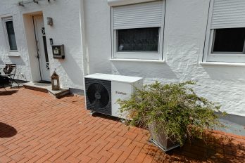 Vor der Hauswand eines Reihenhauses steht eine Vaillant Luft/Wasserwärmepumpe