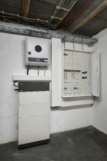 Das Bild zeigt den Solarregler einer PV-Anlage und einen Batteriespeicher im Keller eines älteren Hauses