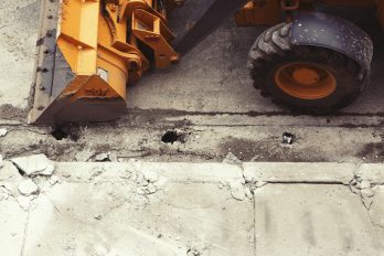 Ein angeschnittener Schaufelbagger auf einer grauen Betonfläche
